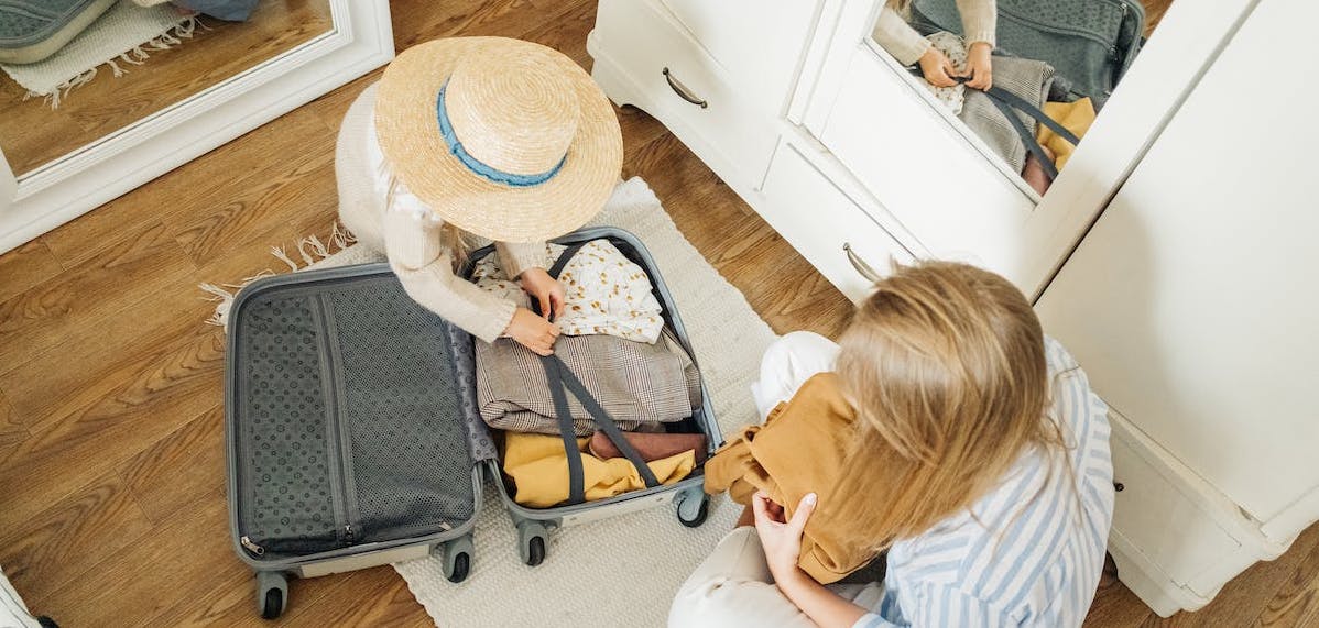deux femmes préparant leur valise pour partir en voyage